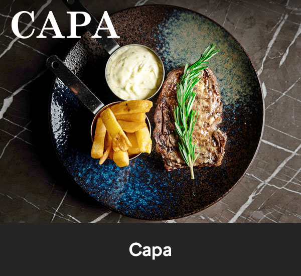 Köttbit med pommes frites och sås serverad på tallrik hos Capa