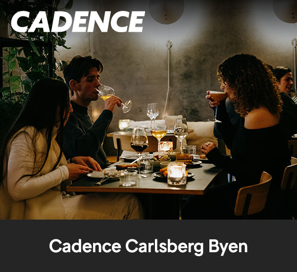 Personer som äter och dricker vin vid bord i restaurangmiljö hos Cadence Carlsberg Byen