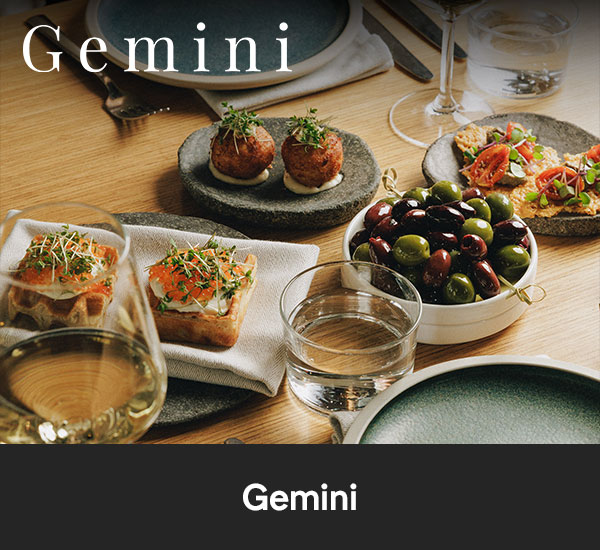 Smårätter och snacks serverade på bord i restaurangmiljö hos Gemini