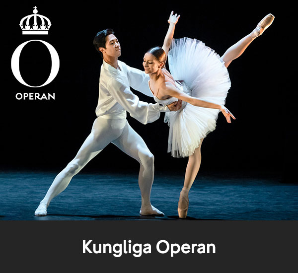 Två balettdansare i vit kostym som uppträder på scen hos Kungliga Operan
